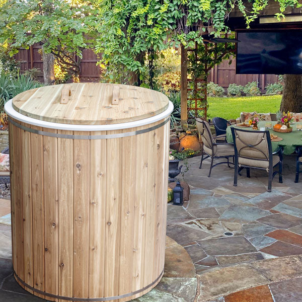 A Dundalk LeisureCraft The Baltic Cold Plunge Tub from the Canadian Timber Collection sitting on a patio.