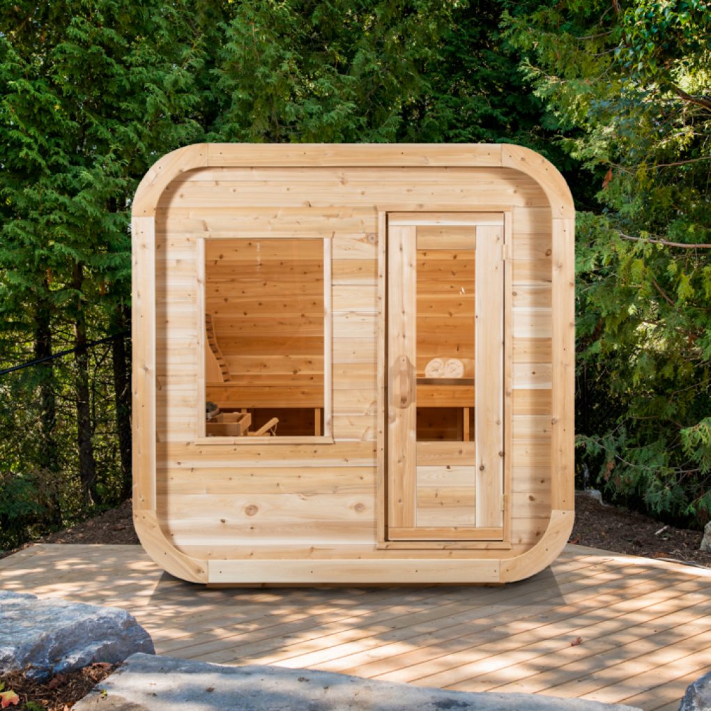 A Dundalk LeisureCraft Luna Sauna, made from Eastern White Cedar, nestled in the woods.