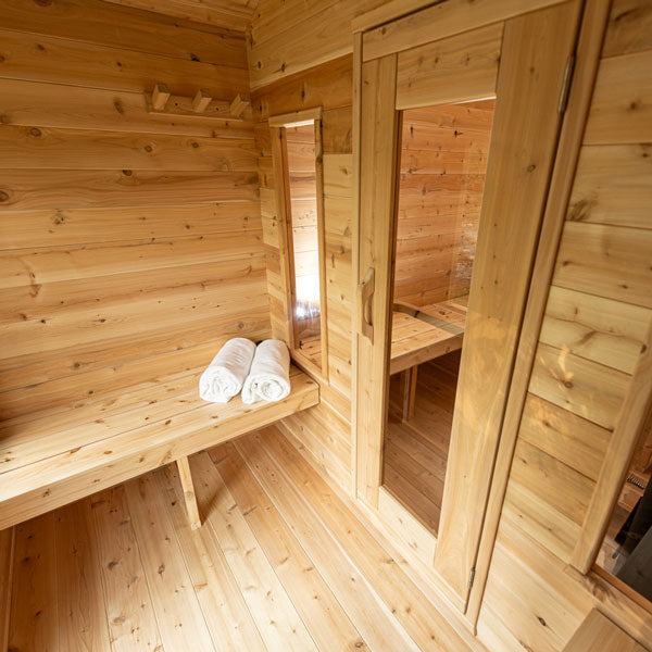 An Dundalk Canadian Timber CT Georgian Cabin Sauna with Changing Room from Dundalk LeisureCraft, with a bench and towels.