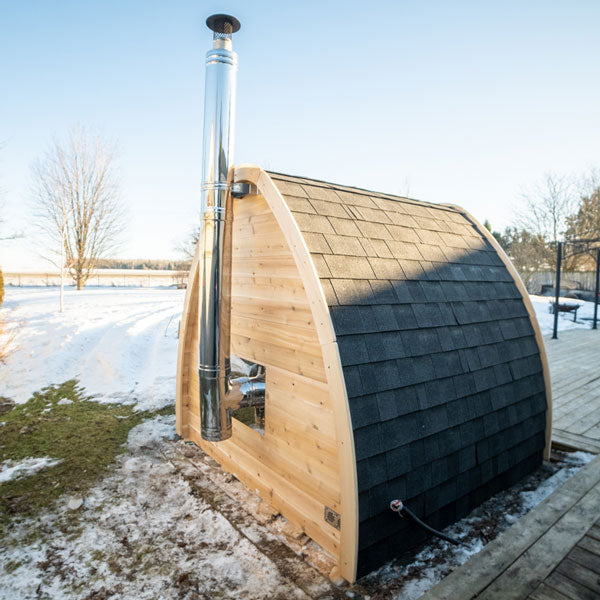 A tranquil Dundalk Canadian Timber CT MiniPOD Sauna, nestled in the snowy Dundalk LeisureCraft timber retreat.
