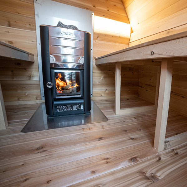 A Dundalk Canadian Timber CT MiniPOD Sauna retreat with a wood burning stove.