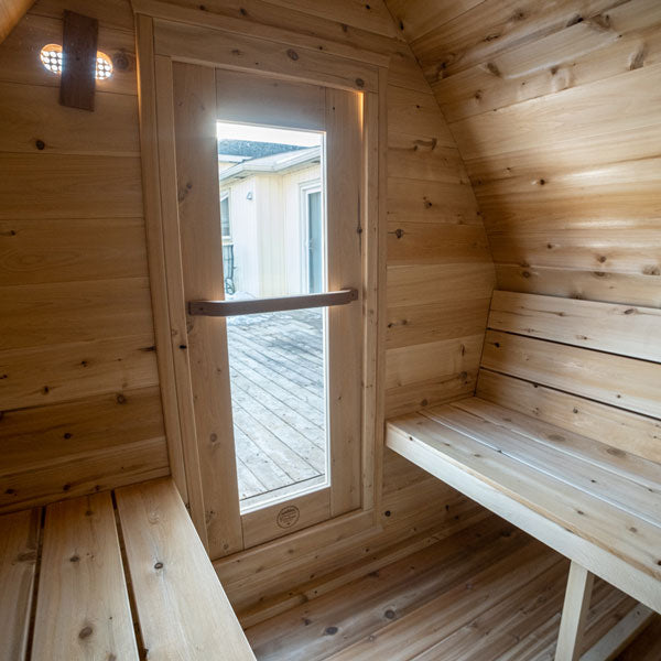 The interior of a Dundalk Canadian Timber CT MiniPOD Sauna retreat with benches and a window by Dundalk LeisureCraft.