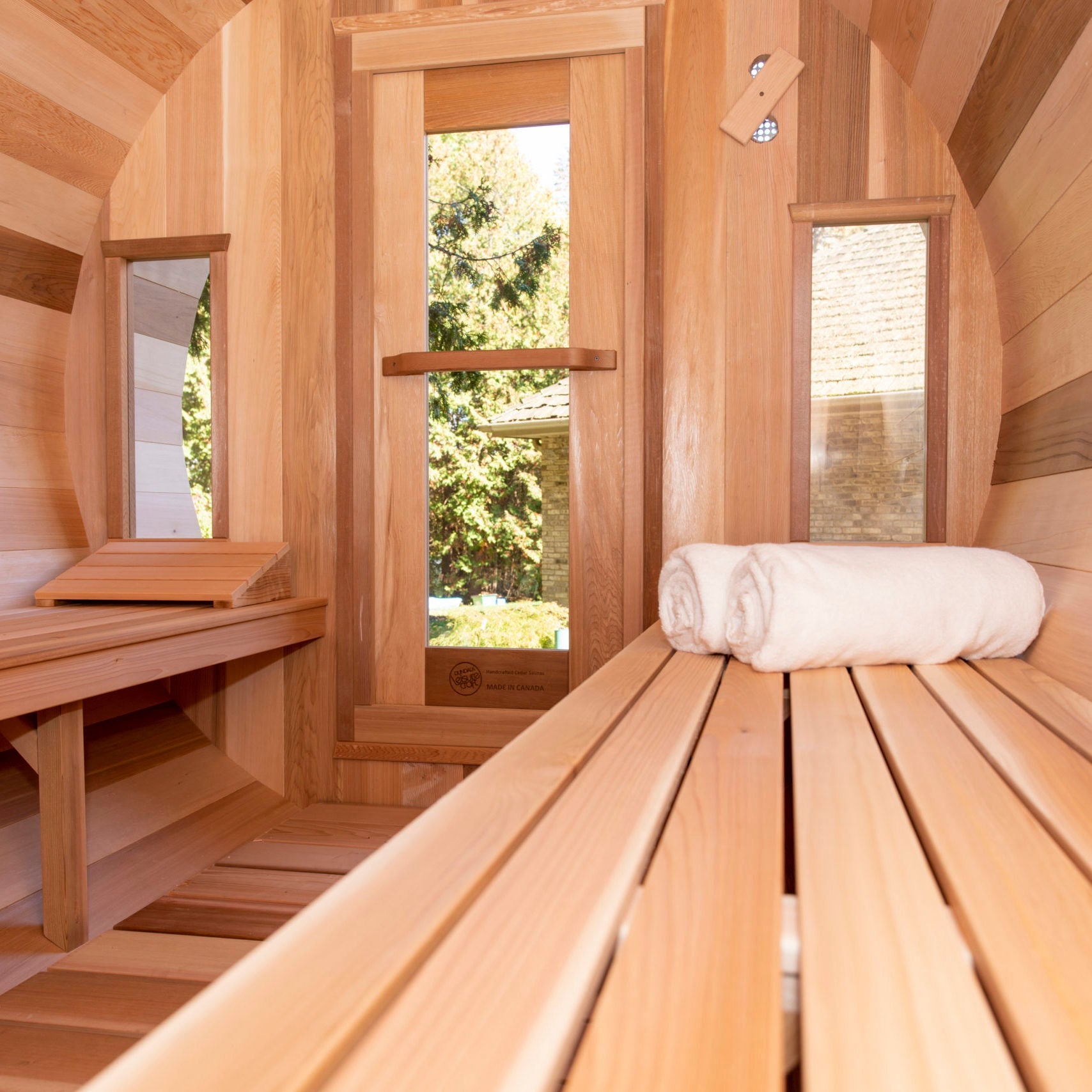 A Dundalk Leisurecraft Cedar Barrel Sauna made of Canadian Timber, providing a tranquil sauna experience.