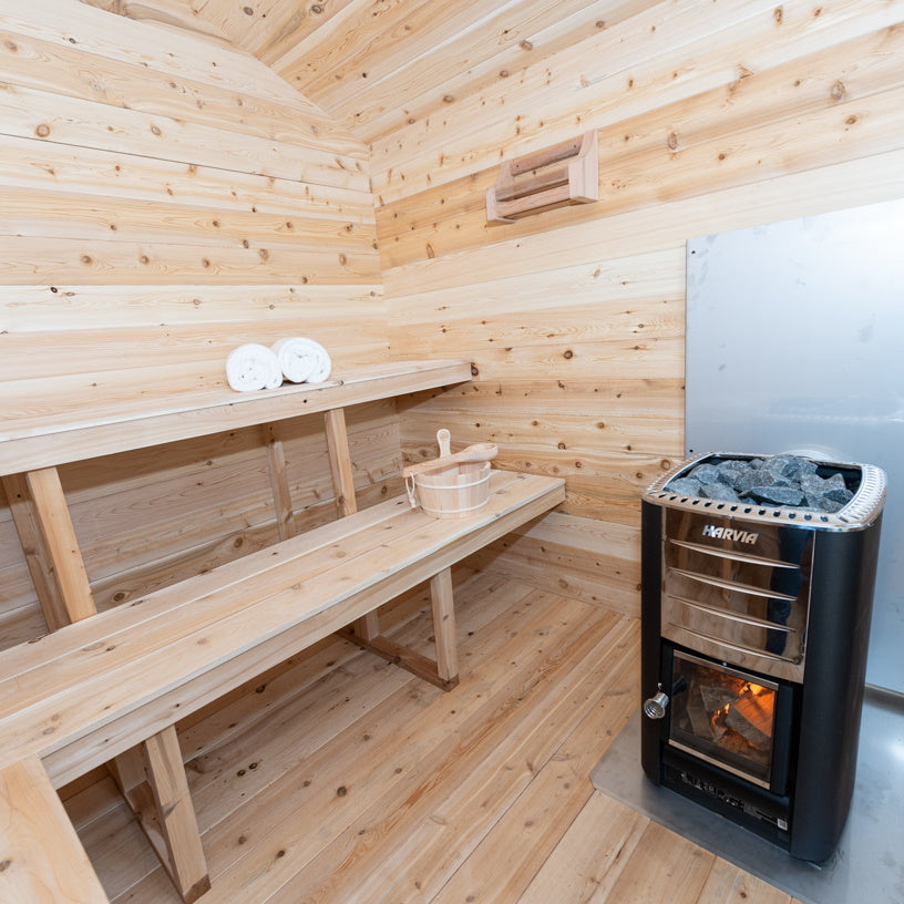 A luxurious Dundalk Canadian Timber Georgian Cabin Sauna, made with Eastern White Cedar, featuring a wood burning stove for the ultimate relaxation and recovery space.