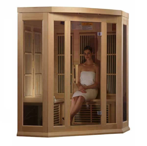 A woman enjoying the soothing warmth of a Maxxus 3-Person Corner Low EMF FAR Infrared Sauna (Canadian Hemlock) from Maxxus Saunas.
