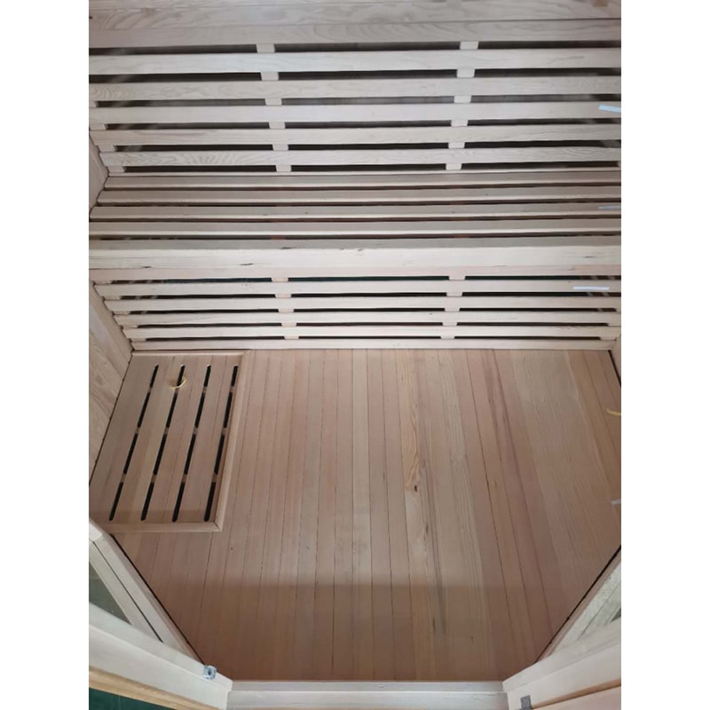 A SunRay Tiburon 4 Person Traditional Sauna HL400SN with wooden slats on the floor and a heater.